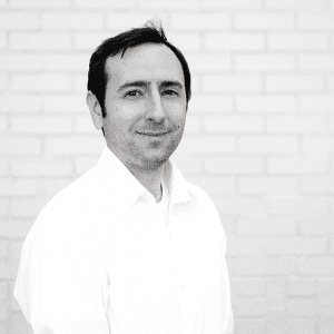 A man standing in front of a brick wall.