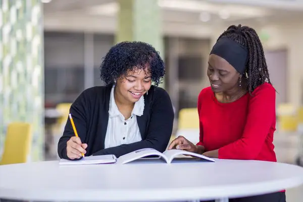 Two women are studying together at a table.