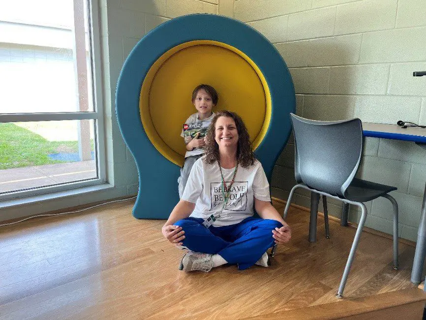 A woman and child sitting in the middle of a room.